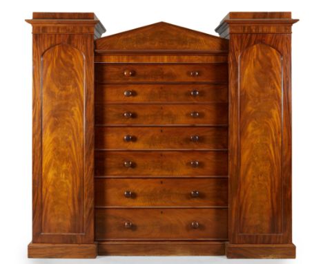 A Victorian mahogany compactum wardrobe, third quarter 19th century, the central arched top above six graduated drawers, one 