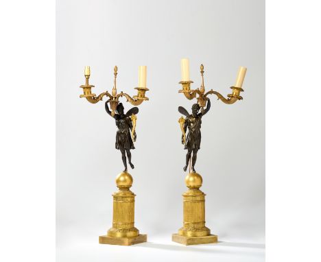 A pair of Empire gilt and patinated bronze twin-light candelabra, first half 19th century, each with a male or female classic