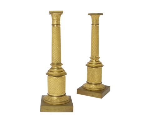 A pair of French gilt-bronze candlesticks adapted from candelabra bases, first half 19th century, each of column form, cast w