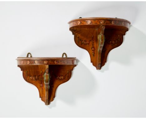 A pair of Edwardian polychrome decorated satinwood wall brackets, early 20th century, each with demi-lune shelf above scroll 