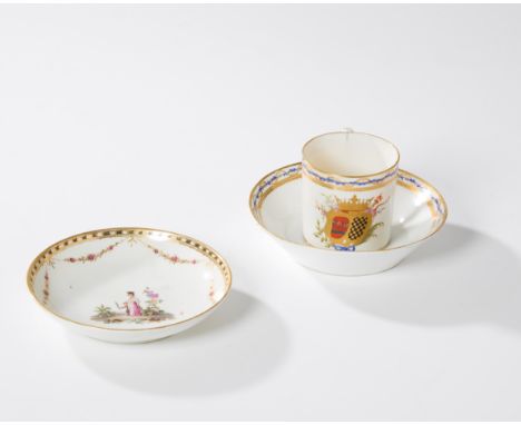 A Nyon porcelain armorial coffee can and two Nyon porcelain saucers, late 18th century, blue fish marks, the can decorated wi