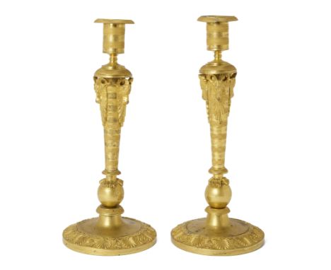 A pair of Russian ormolu candlesticks, early 19th century, each with bands of engine turned decoration, the stem surmounted b