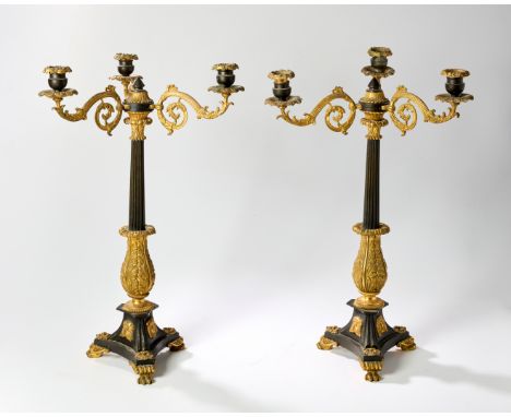 A pair of English gilt and patinated bronze three-light candelabra, of Regency style, 19th century, each with scroll branches