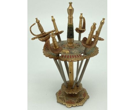 A vintage set of 6 Toledo sword cocktail sticks. Painted detail to the stand and sword guards. Swords have varying style of g