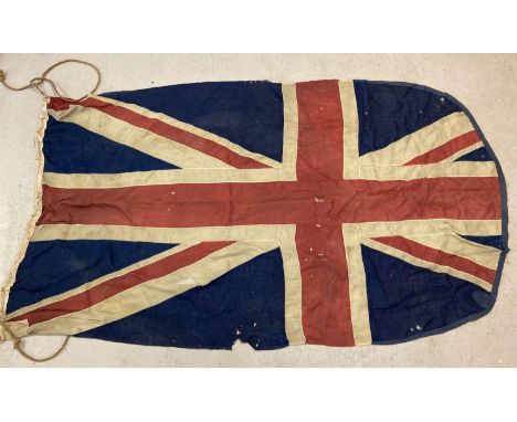 A large vintage Union Jack flag. One end banded. Shows signs of age related damage. Approx. 124 x 212cm.  