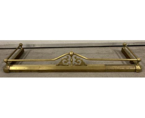 A vintage extending brass fire fender with finial, rail and scroll detail.  