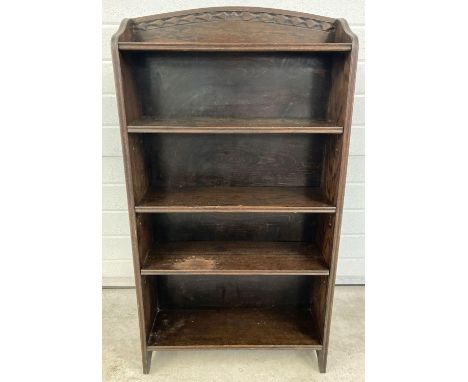 A vintage dark oak bookcase with adjustable shelves and carved detail to shaped top. Approx. 115 x 61cm.  
