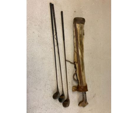 A vintage canvas and leather pencil golf club bag together with 5 vintage driver clubs. To include a Fred Thomas Special and 