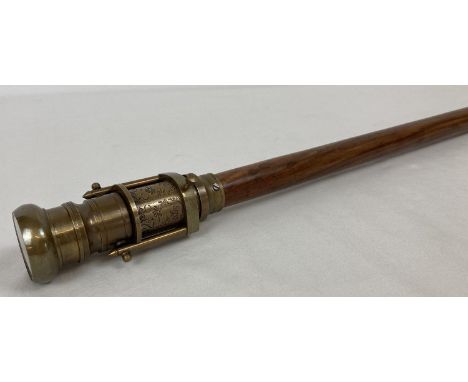 A reproduction wood and brass walking stick with swivel top telescope/compass handle. Approx. 96cm long.  