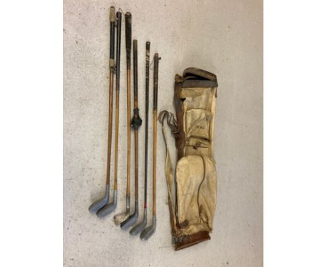 A vintage canvas and leather pencil golf club bag together with 6 vintage golf clubs in varying conditions. To include Mill &