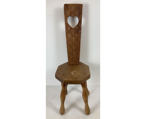 A vintage medium oak highly carved Welsh spinning chair with four legs. Heart detail to back with floral carving to back and 