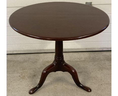 A Georgian mahogany tip top table on tripod footed pedestal base. With original brass catch to back. Shows signs of restorati