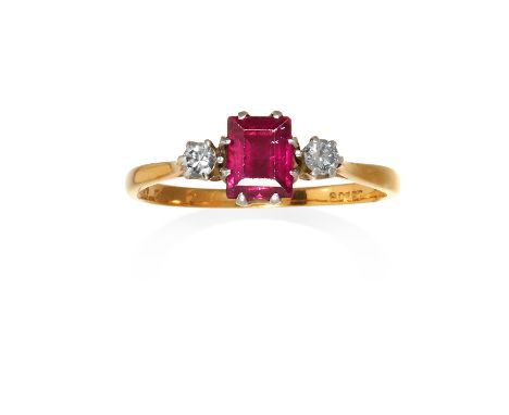 A RUBY AND DIAMOND THREE STONE RING in 18ct yellow gold and platinum, the step cut ruby between round cut diamonds, stamped 1