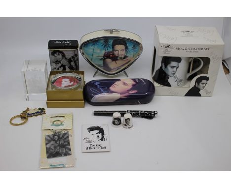 A selection of Elvis memorabilia to include Elvis bedside clock, Paperweight, Cigarette Tin, Pen, 3D Laser Etched Crystal of 