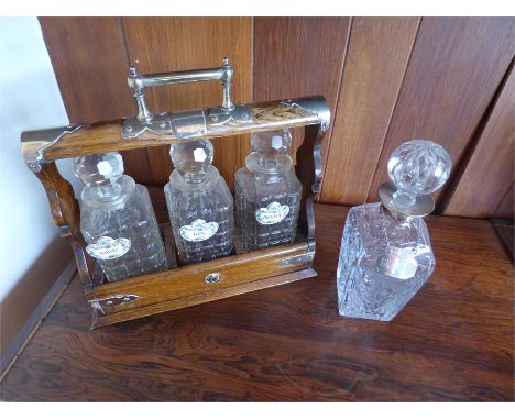 Edwadian oak three bottle tantalus with enamel labels with another decanter with silver brandy label LACKING KEY.