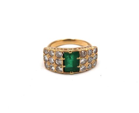 An unmarked, possibly 18ct, yellow gold, emerald and diamond ring, the baguette cut emerald flanked by approx 18 0.1ct diamon