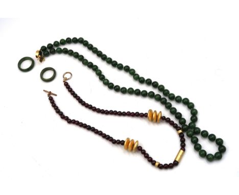 A nephrite jade bead necklace and two band rings, Size P and L, together with a red bead necklace.