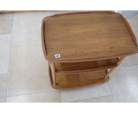 An Ercol blonde elm Windsor three tier drinks trolley raised on casters. 71cm long x 46cm wide x 76cm high.