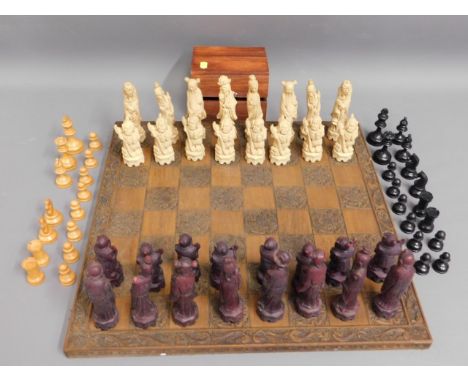 An Oriental chess set, king 5in tall, some faults, a carved wooden set, lacking white bishop &amp; an 18in square board