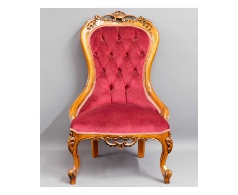 An upholstered carved walnut button back nursing chair, 37.25in high to back
