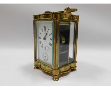 A brass serpentine fronted carriage clock, 6in tall inc. handle