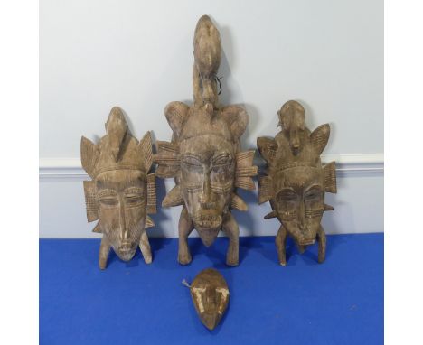 Tribal art: three Senufo Masks, carved in traditional form, each H: 61cm, 46cm and 42cm,&nbsp; together with another smaller 