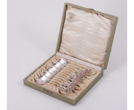 A cased set of twelve silver Art Nouveau spoons, circa 1910, showing the influence of Archibald Knox, the stylised pierced te