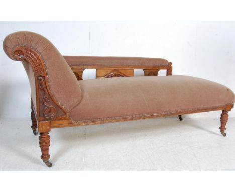 A 19th century Victorian chaise longue having a carved mahogany frame with a pierced arm rest raised on turned legs. Upholste