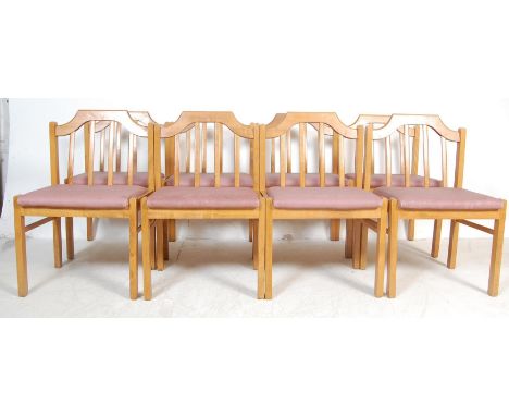 A set of eight vintage late 20th century oak dining chairs having a chamfered shaped top rail over sloping back bar rails ato