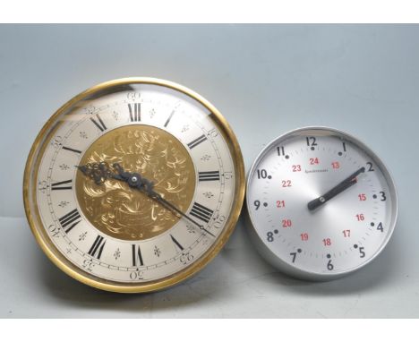Two vintage 20th century Synchronome wall clock of circular form. One clock has a silvered clock face with Arabic numerals to