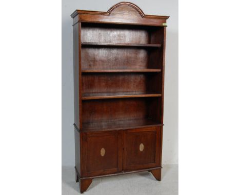 An early 20th Century 1920s oak open fronted bookcase having an arched cornice top with polychrome floral decoration. The boo