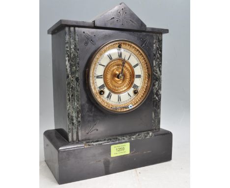 An antique Victorian circa 1900 slate 8 day mantel clock of architectural form having a brass and white enamel clock face wit