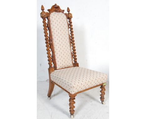 A 19th century Victorian mahogany nursing chair. The chair having a high back with carved crest flanked by two barley twist c