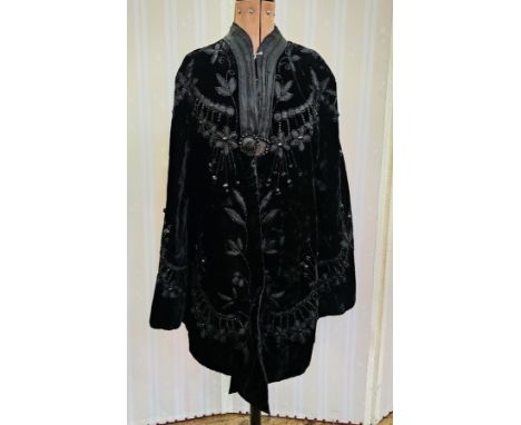A Victorian black velvet evening cape, three quarter length heavily embroidered with faux jet, satin ribbon and braid, a hook