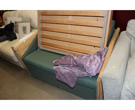 A cane and upholstered sofa bed