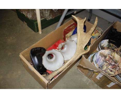 A box containing advertising tins, glass light shades, antlers etc.