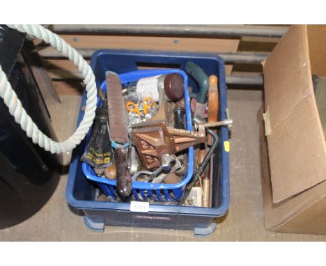 A plastic crate containing a quantity of hand tools to include wire brushes, hand saws, spanners and a P&B bench mounting vic