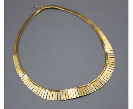 An Italian three-colour 18k collaret of graduated flexible baton design, gross 38 grams.