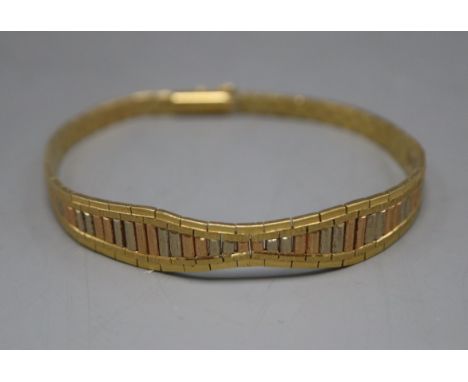 A three-colour yellow metal (tests as 18ct) flexible baton bracelet, gross 18 grams.