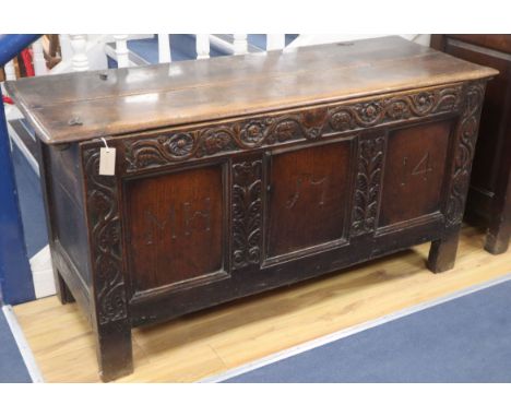 A large 18th century oak coffer, the panelled front carved with the initials M H and dated 1714 W.145cm