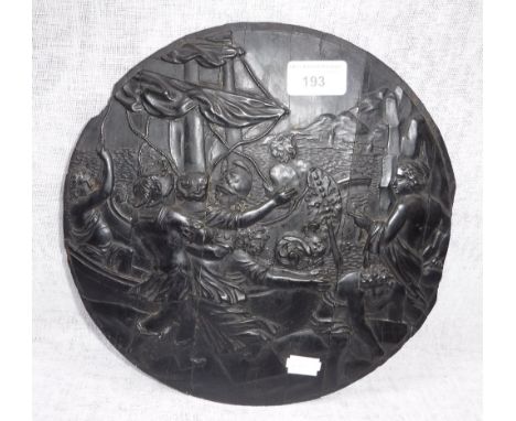 A CLASSICAL STYLE CARVED EBONY ROUNDEL decorated with figures by a boat with a landscape to the distance