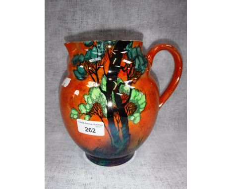 A CARLTONWARE JUG decorated with a tree against an orange ground 