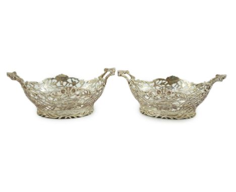 A pair of Edwardian pierced silver two handled bon bon dishes, by William Comyns, with floral scroll borders and engraved wit