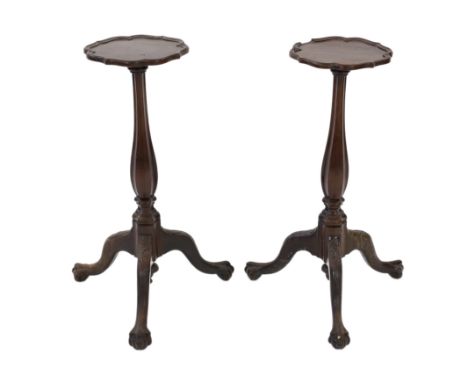 A pair of 18th century Dutch mahogany and oak torchere stands, with piecrust tops and fluted baluster stems on scroll carved 