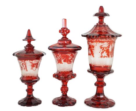 Three large Bohemian ruby stained glass goblets and covers, late 19th century, each wheel engraved with hunting scenes, 38.5c