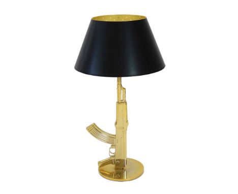 A Philippe Starck gilt metal kalashnikov table lamp, with gothic inscription happiness is a hot gun to the base and original 