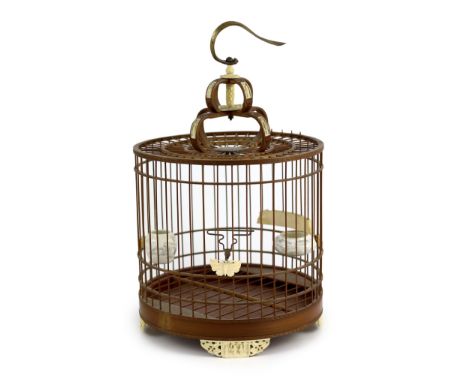 A Chinese bamboo and Guangzhou ivory mounted bird cage, late Qing dynasty, with two Guangxu mark and period porcelain bird fe