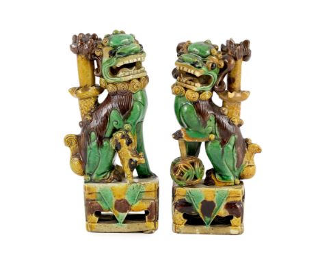 A pair of Chinese sancai-glazed biscuit Buddhist lion joss stick holders, Kangxi period, 15.5 and 16cm high, some restoration