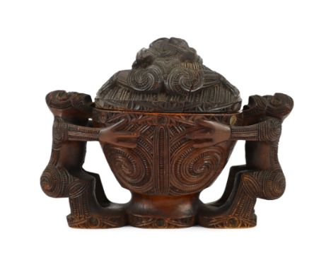A Maori carved wood oblong bowl and cover, kumete, c.1880-1910, probably carved in totara wood with two wrestlers supporting 