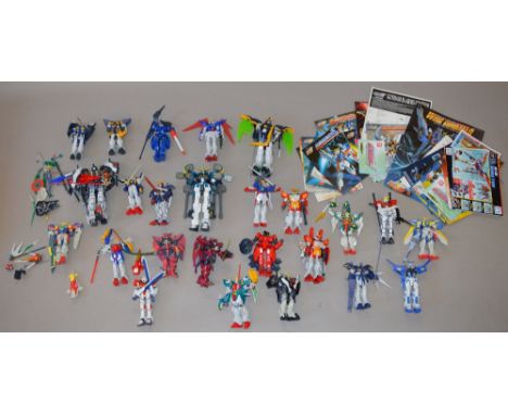 24 x Bandai and TT Hongli Gundam Wing kit built figures, mostly 1:144 scale. Together with 25 instruction leaflets.